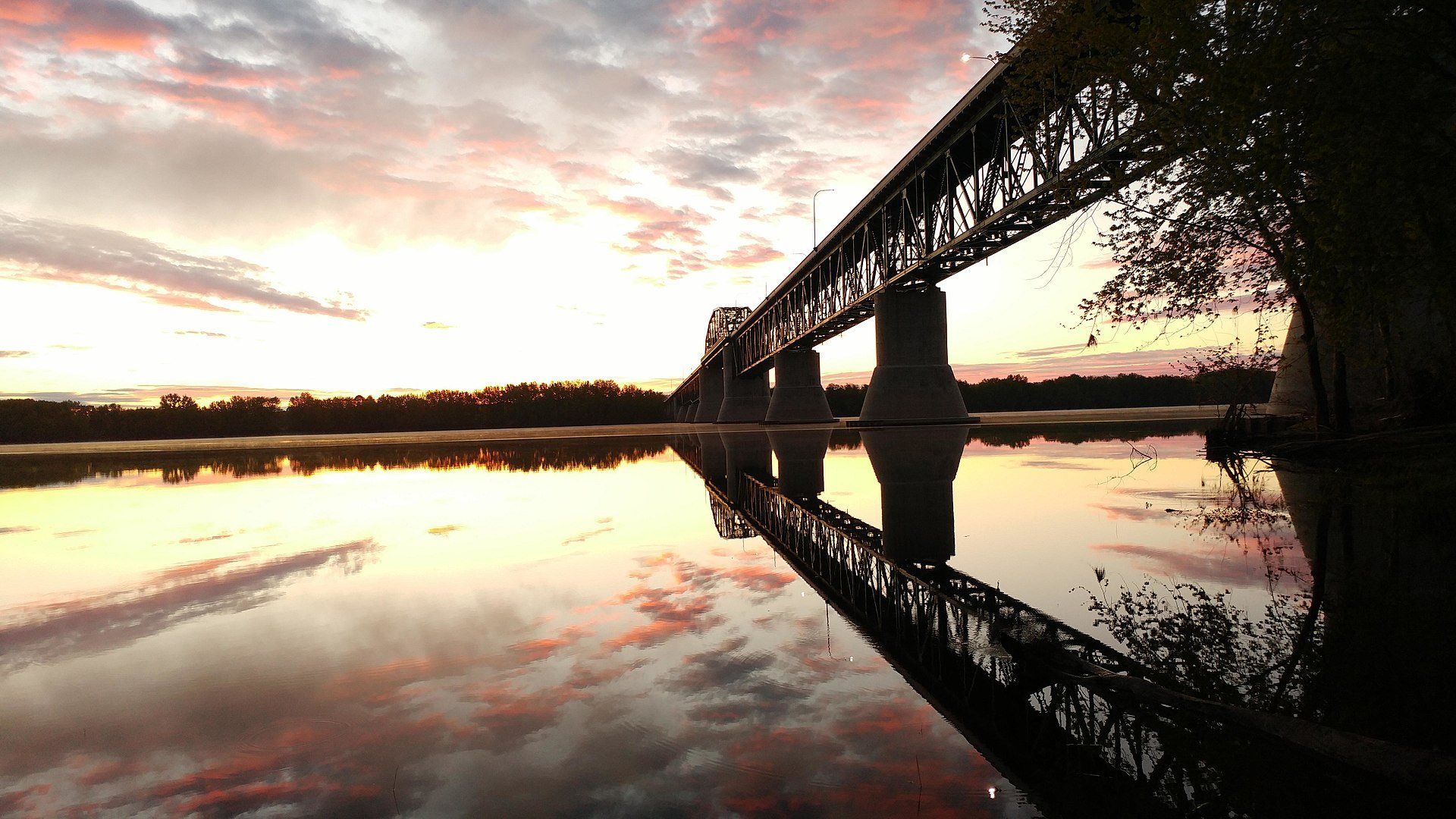 A bridge over a body of water at sunset