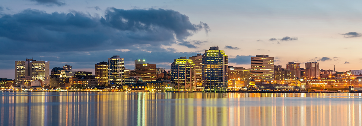 A city skyline overlooking a body of water at night.
