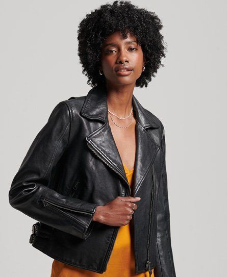 A woman is wearing a black leather jacket and a yellow dress.