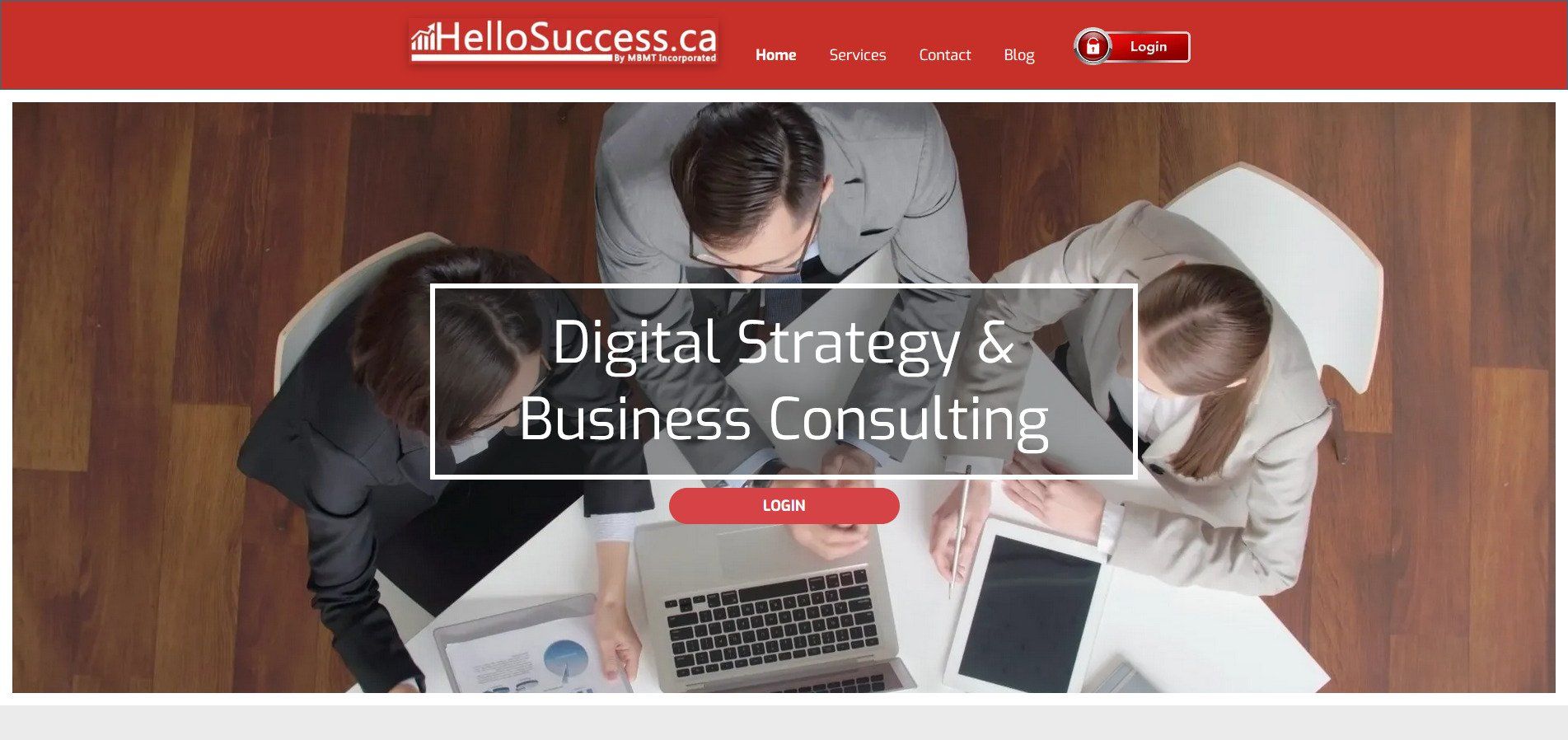 A group of people are sitting around a table looking at a laptop.