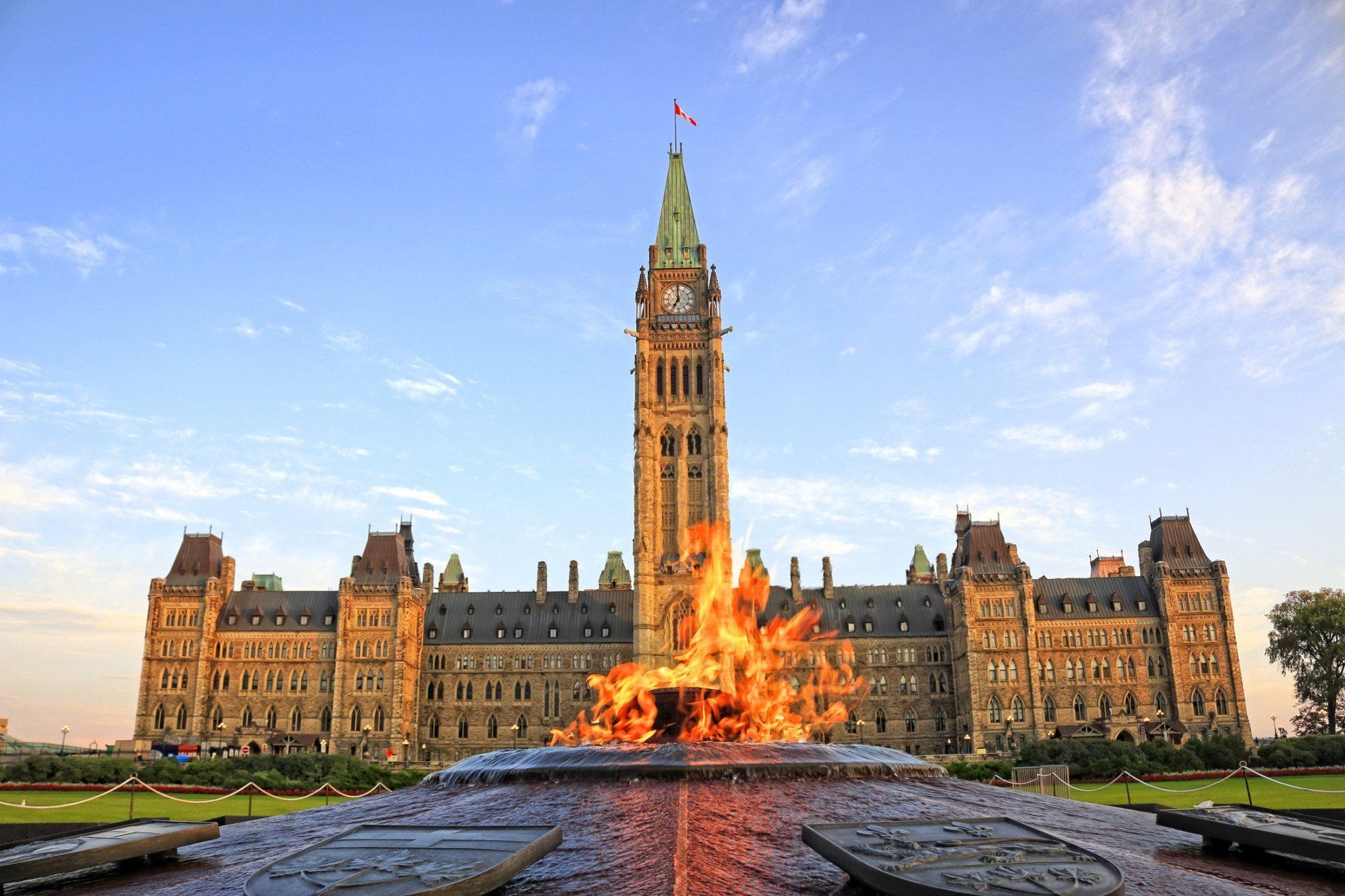 A large building with a clock tower and a fountain in front of it.