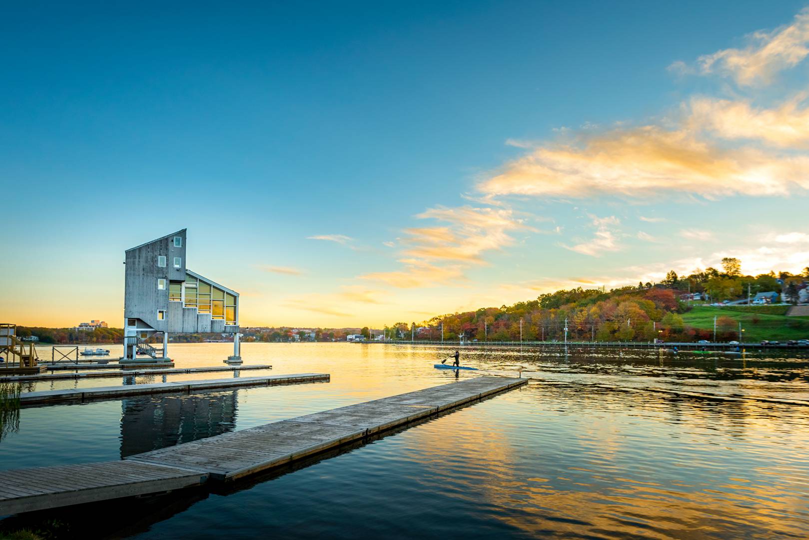 A large body of water with a dock in the foreground and a building in the background.