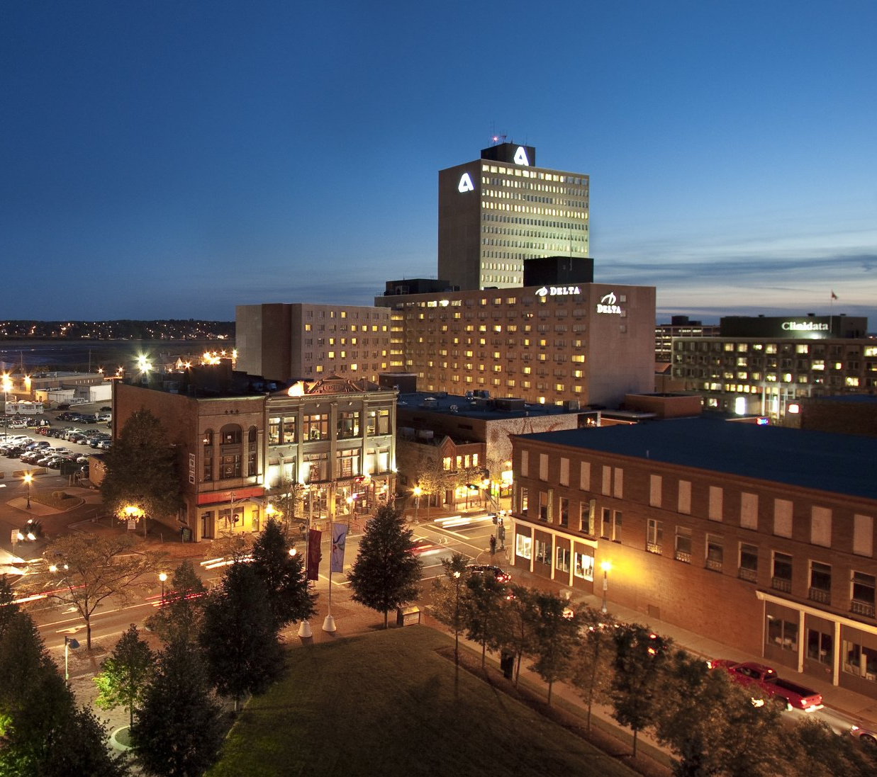 An aerial view of a city at night with a hotel in the background
