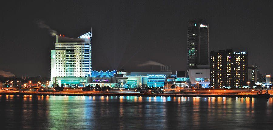 A city skyline at night with a large building in the middle