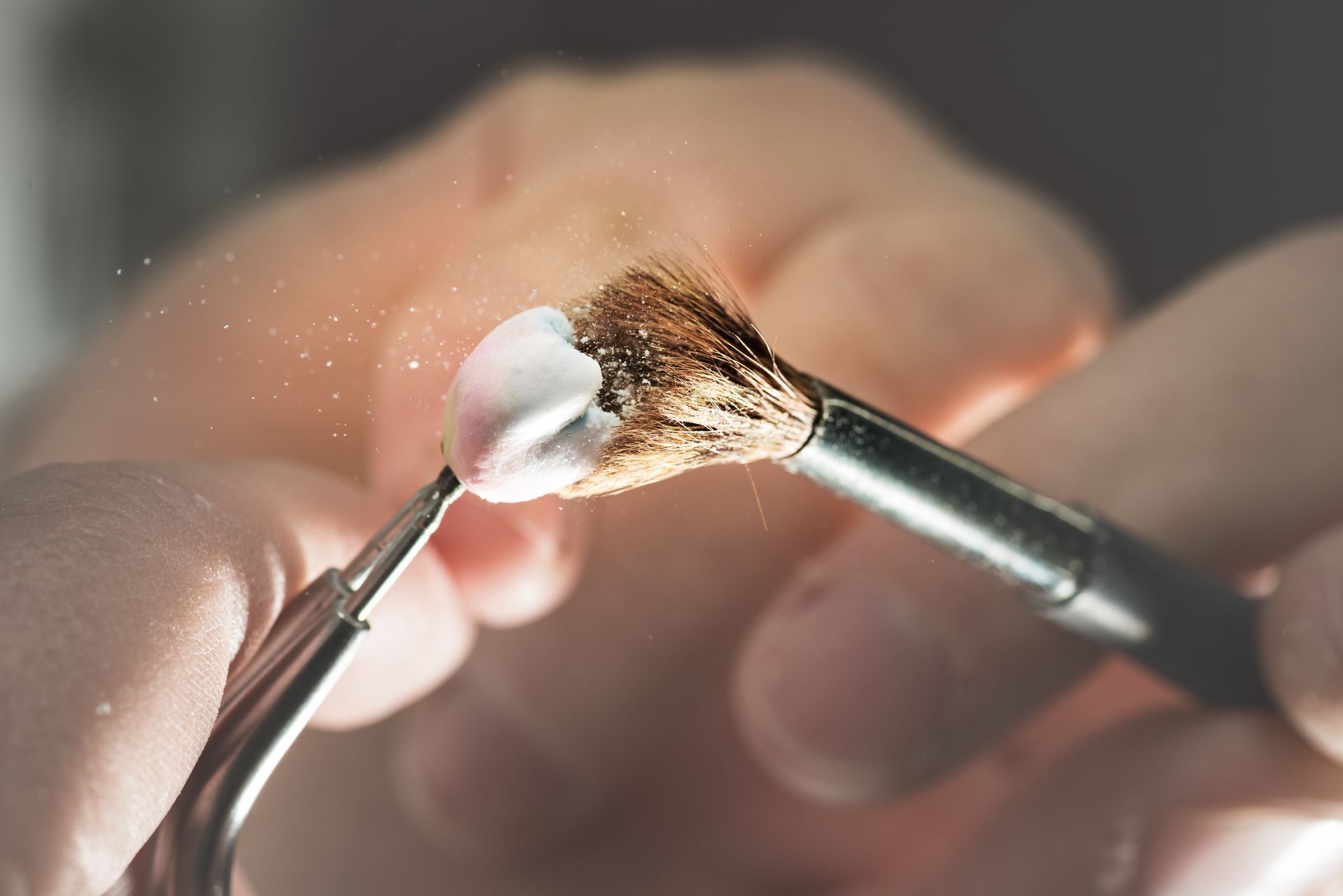 Dentist brushes a tooth implant, representing the cosmetic dental care Athena Dental Associates offers in Athens, GA.