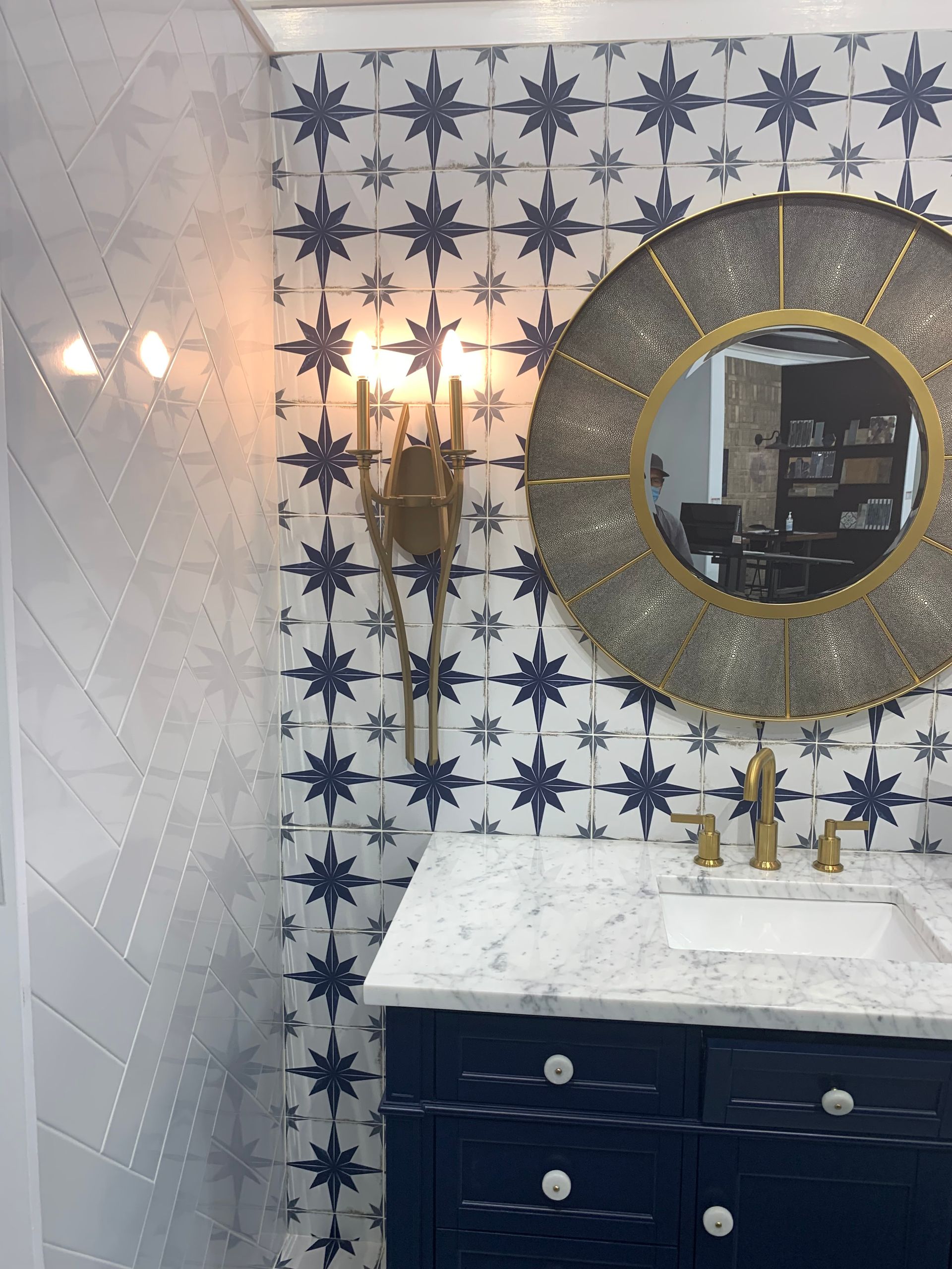 A bathroom with blue cabinets , two sinks , two mirrors and a tub.