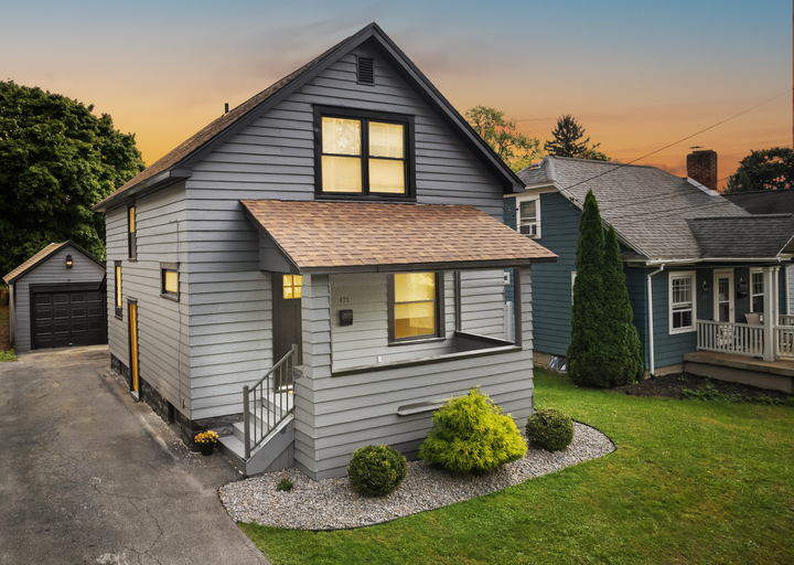 A house with a porch and a garage is for sale