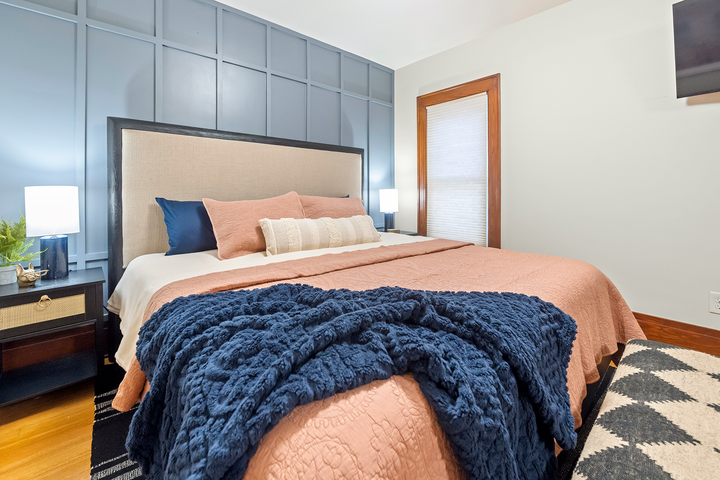 A bedroom with a large bed and a blue blanket on it.