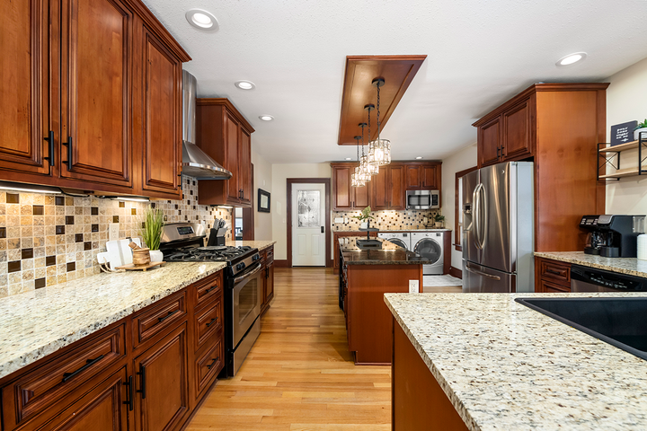 A kitchen with wooden cabinets and granite counter tops.