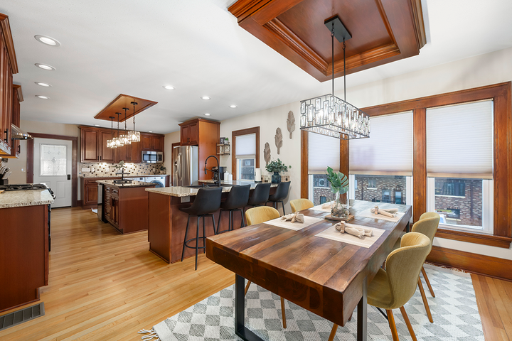 A kitchen and dining room in a house with a wooden table and chairs.