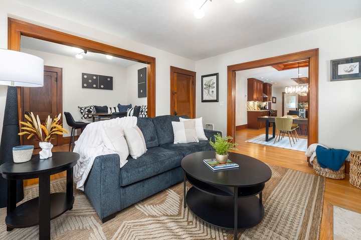 A living room with a blue couch and a black coffee table.