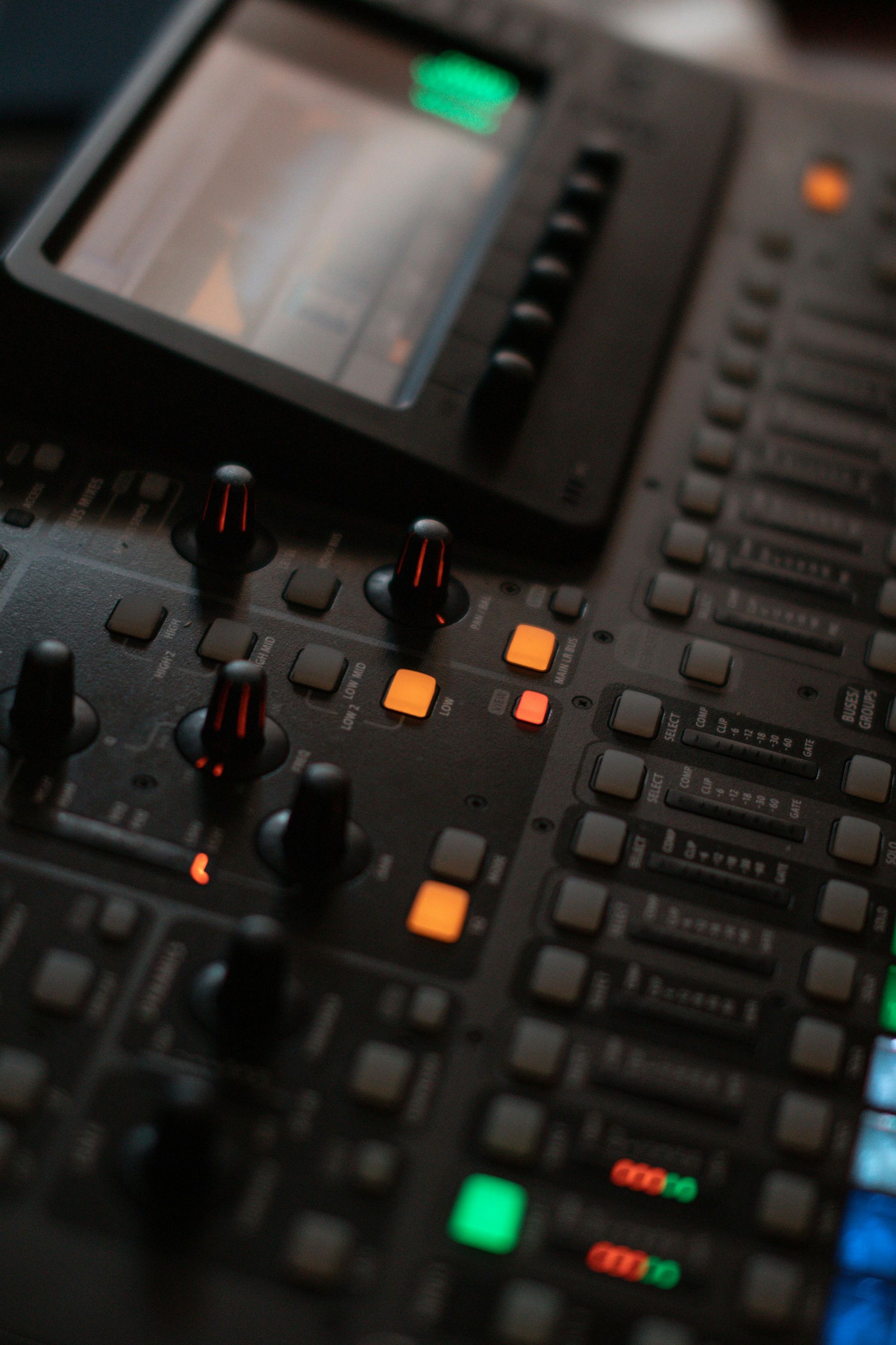 Zwarte mengtafel met knoppen, faders, toetsen en verlichte indicatoren.