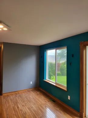 Freshly painted bedroom featuring gray walls and teal accent wall