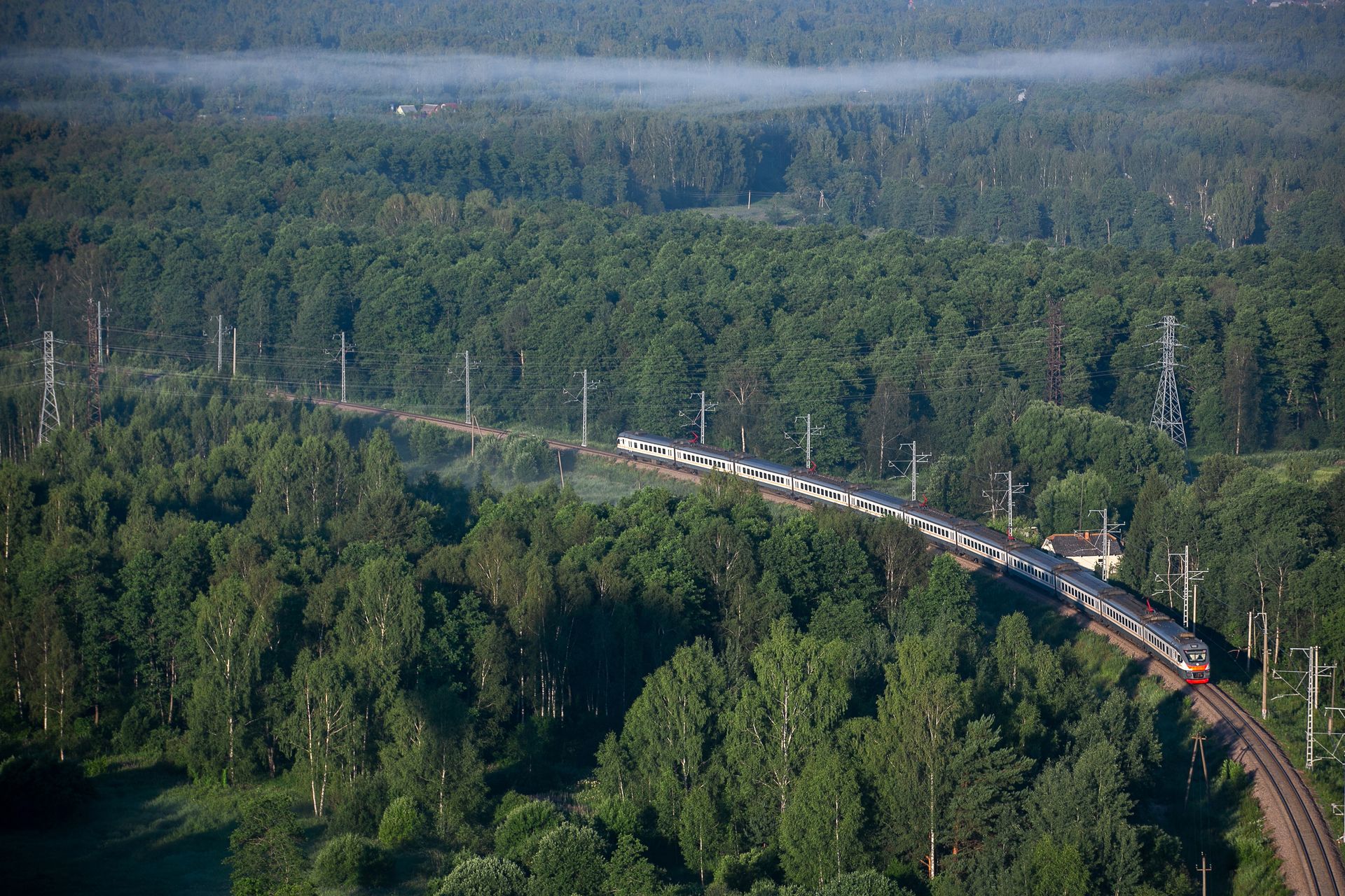Commitments - Scenic view of a train travelling through a forest, emphasising air quality and fresh air.