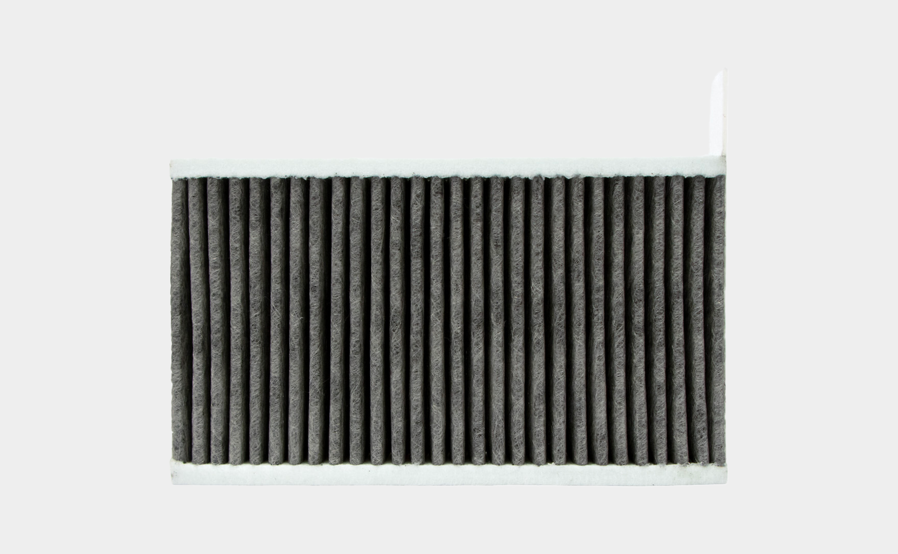 Black pleated cabin air filter on a white background, designed to improve air quality in vehicles.