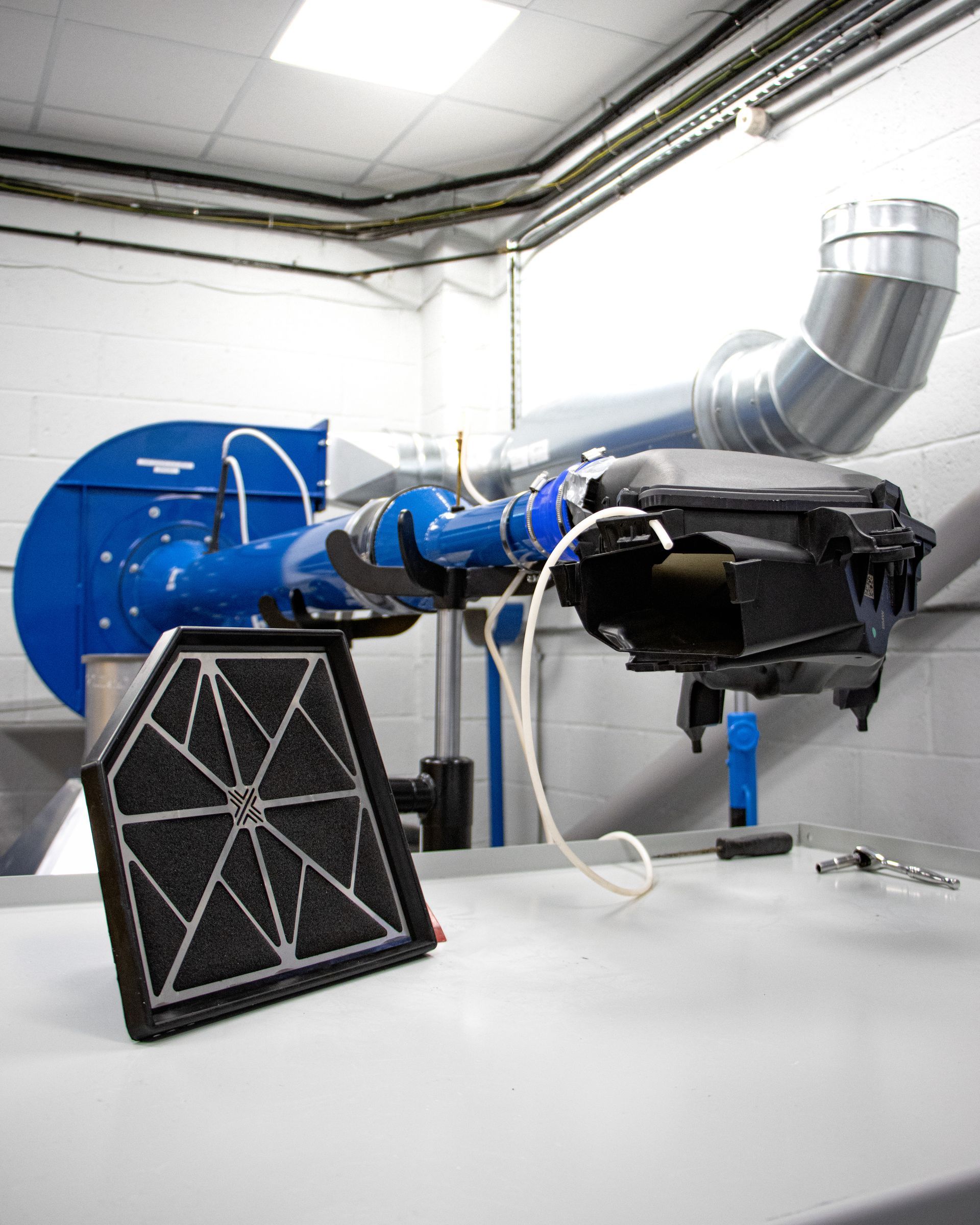 Detailed view of flow bench testing apparatus for automotive components.