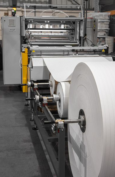 Manufacturing - An advanced pleater machine for HVAC air filters in a manufacturing facility.