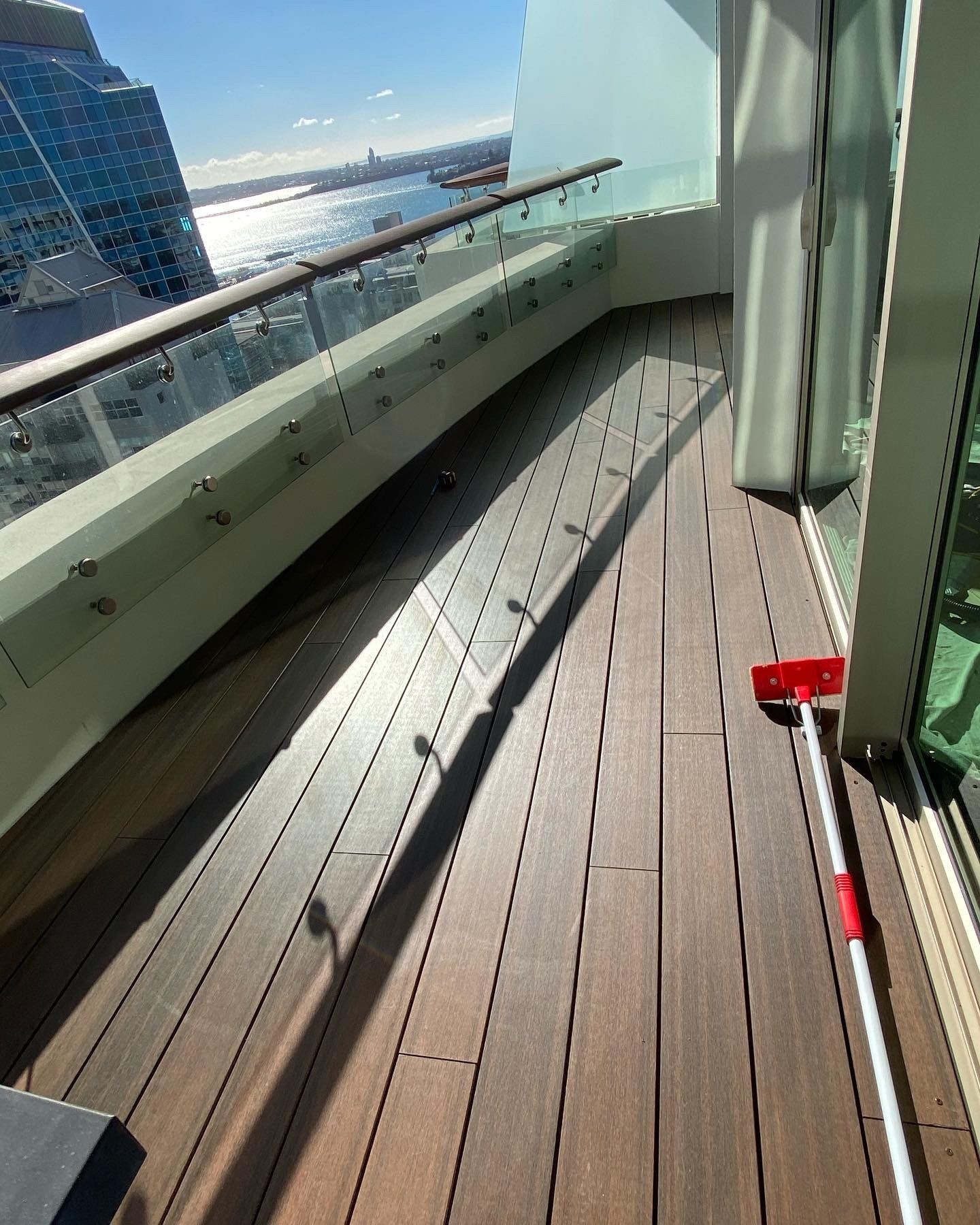 A wooden deck with a red and white mop on it