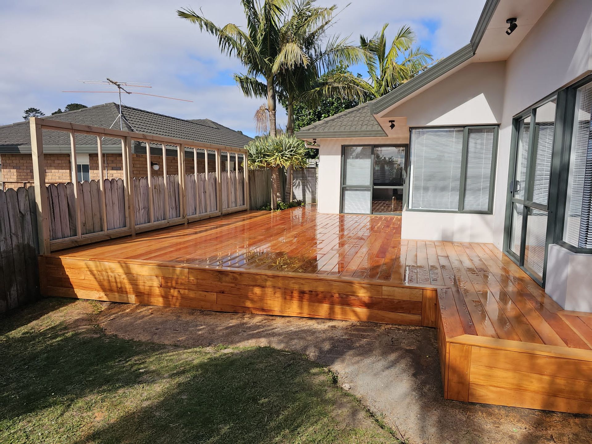 There is a large wooden deck in the backyard of a house.