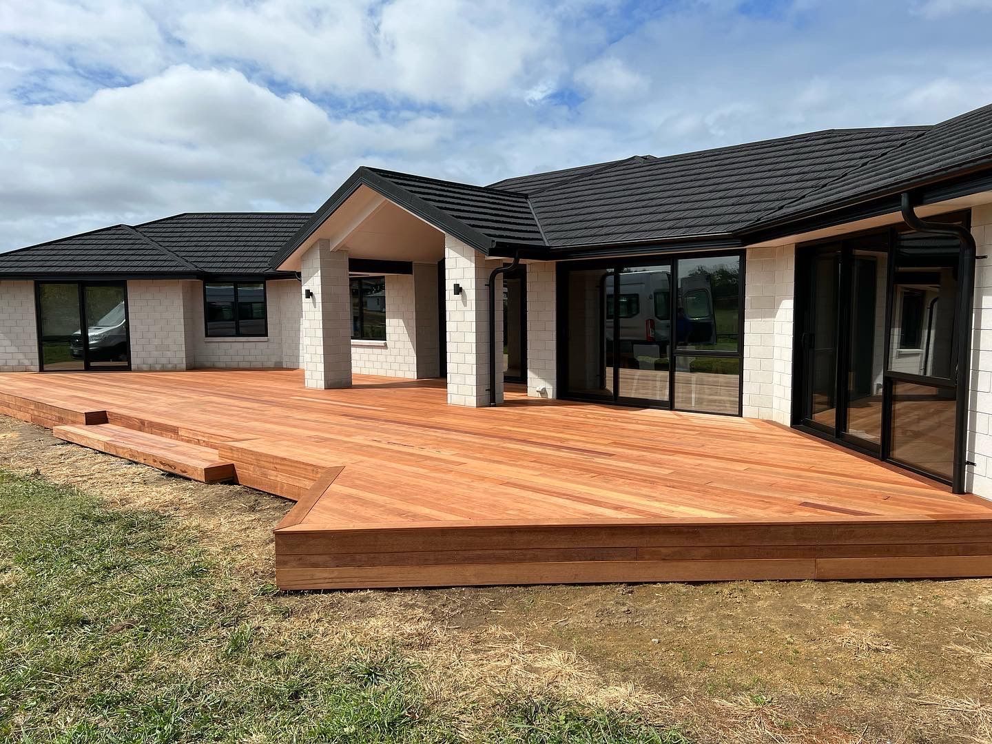 A house with a large wooden deck in front of it.