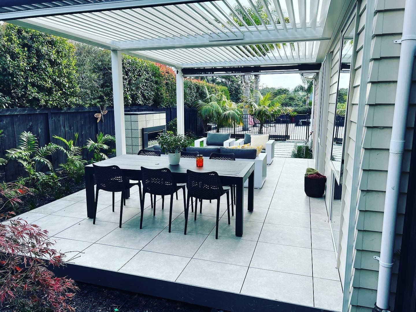 A patio with a table and chairs under a pergola.