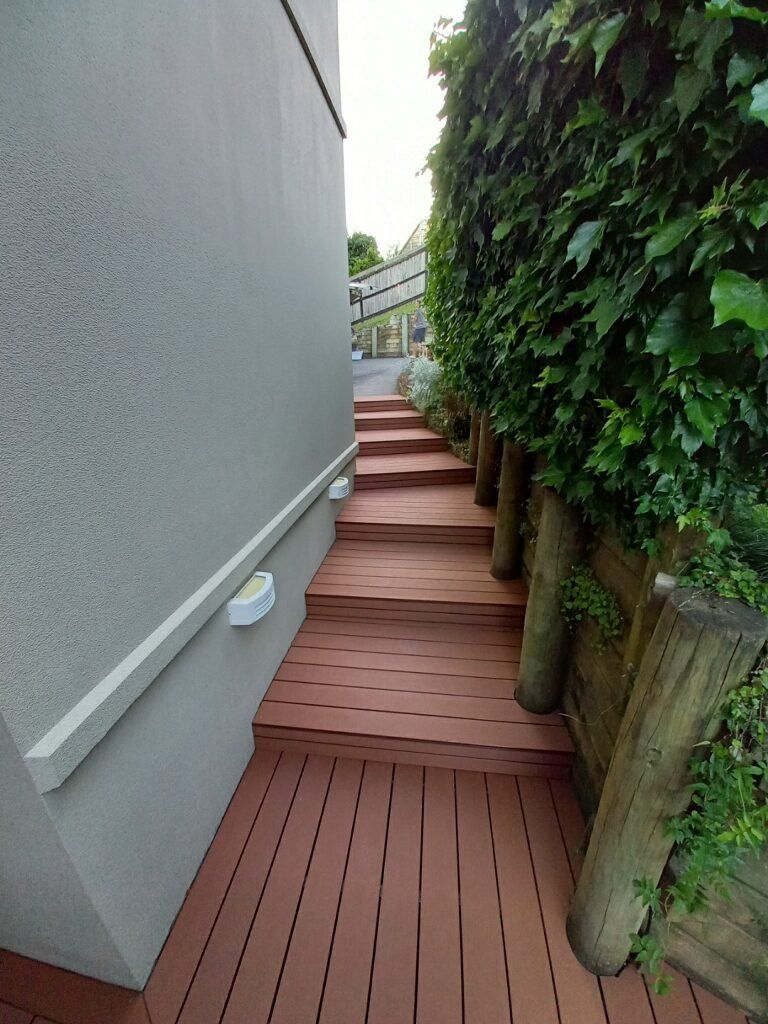 A wooden deck with stairs leading up to a building.