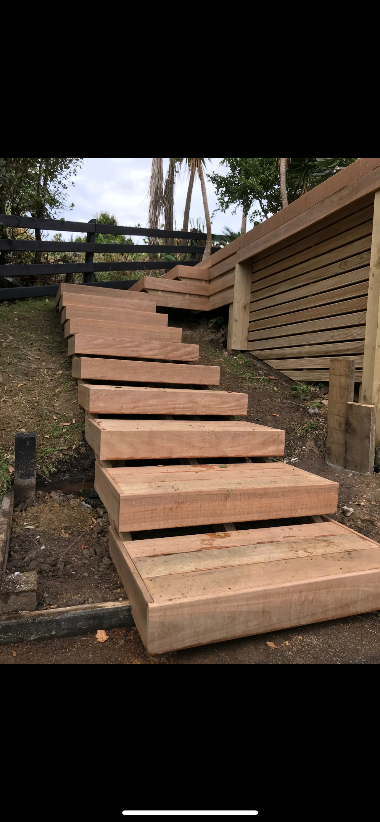 A set of wooden stairs going up a hill.