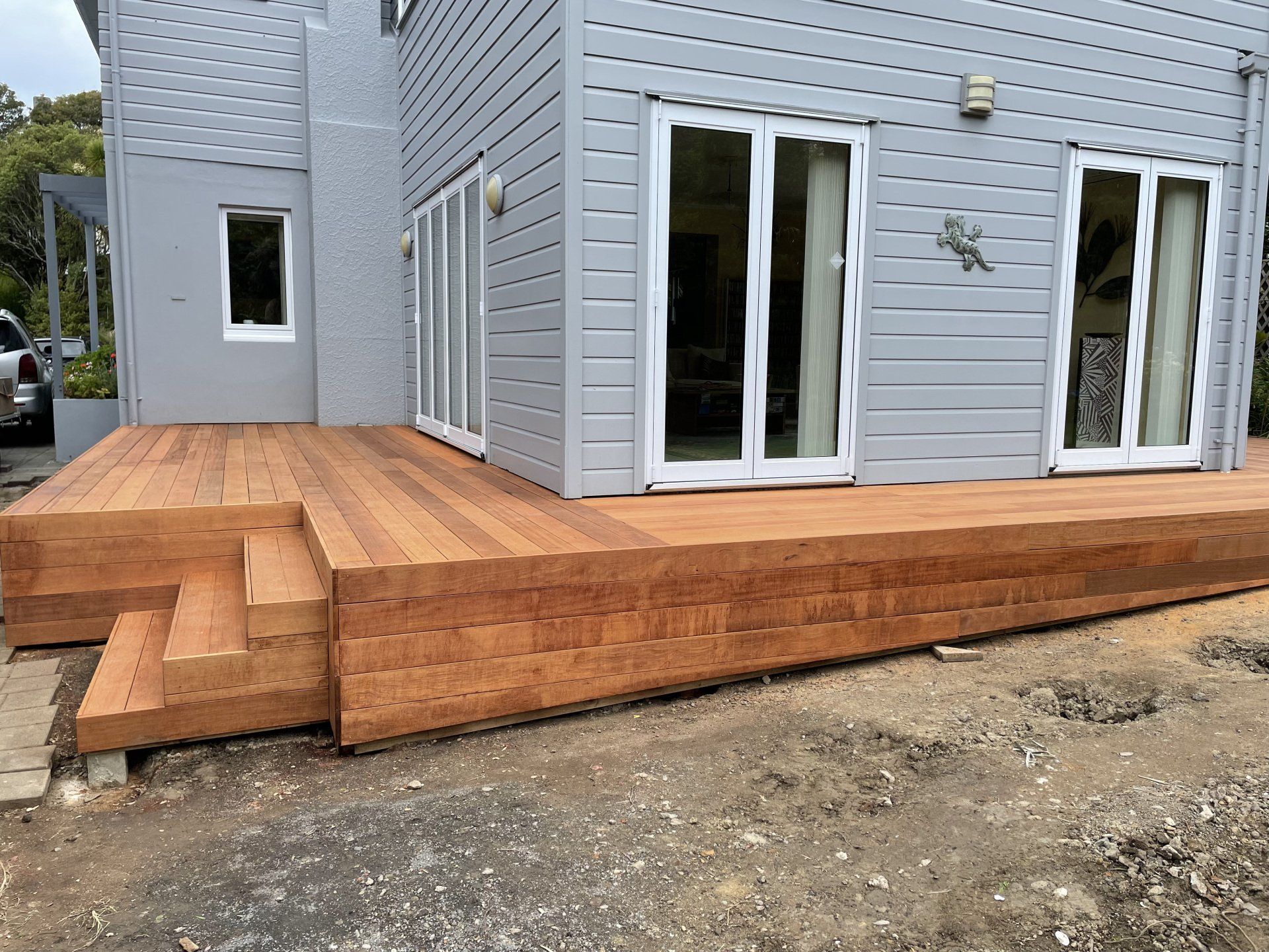 A house with a wooden deck in front of it.