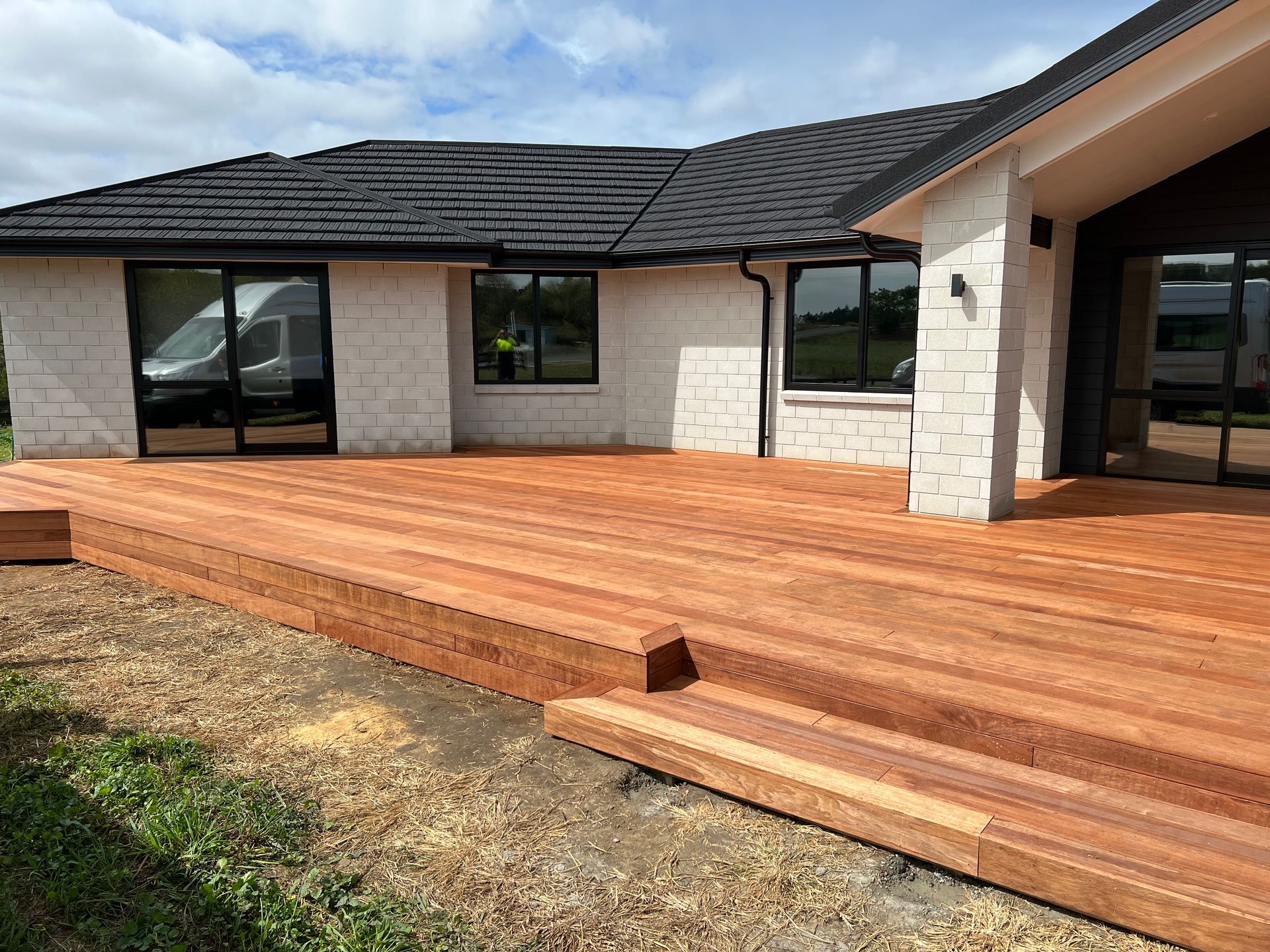 A house with a wooden deck in front of it.