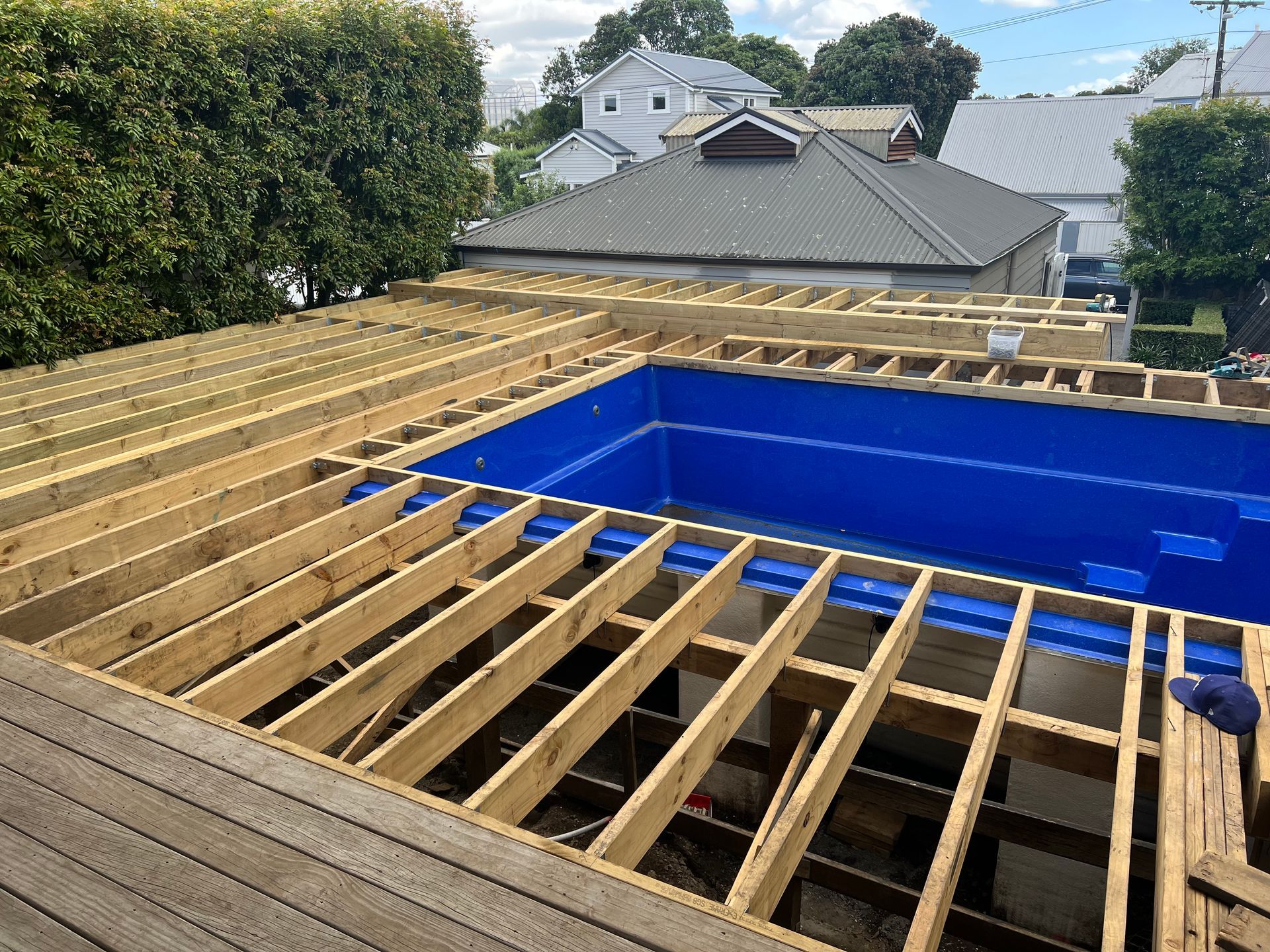 A swimming pool is being built on top of a wooden deck.
