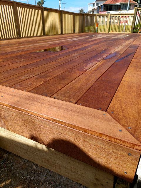 A wooden deck with a wooden fence in the background.