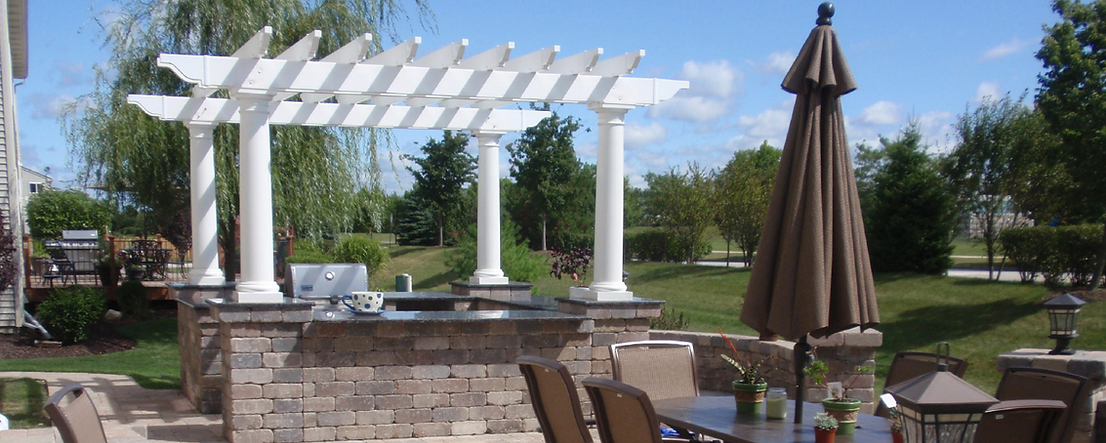 a patio with a table , chairs , umbrellas and a pergola .