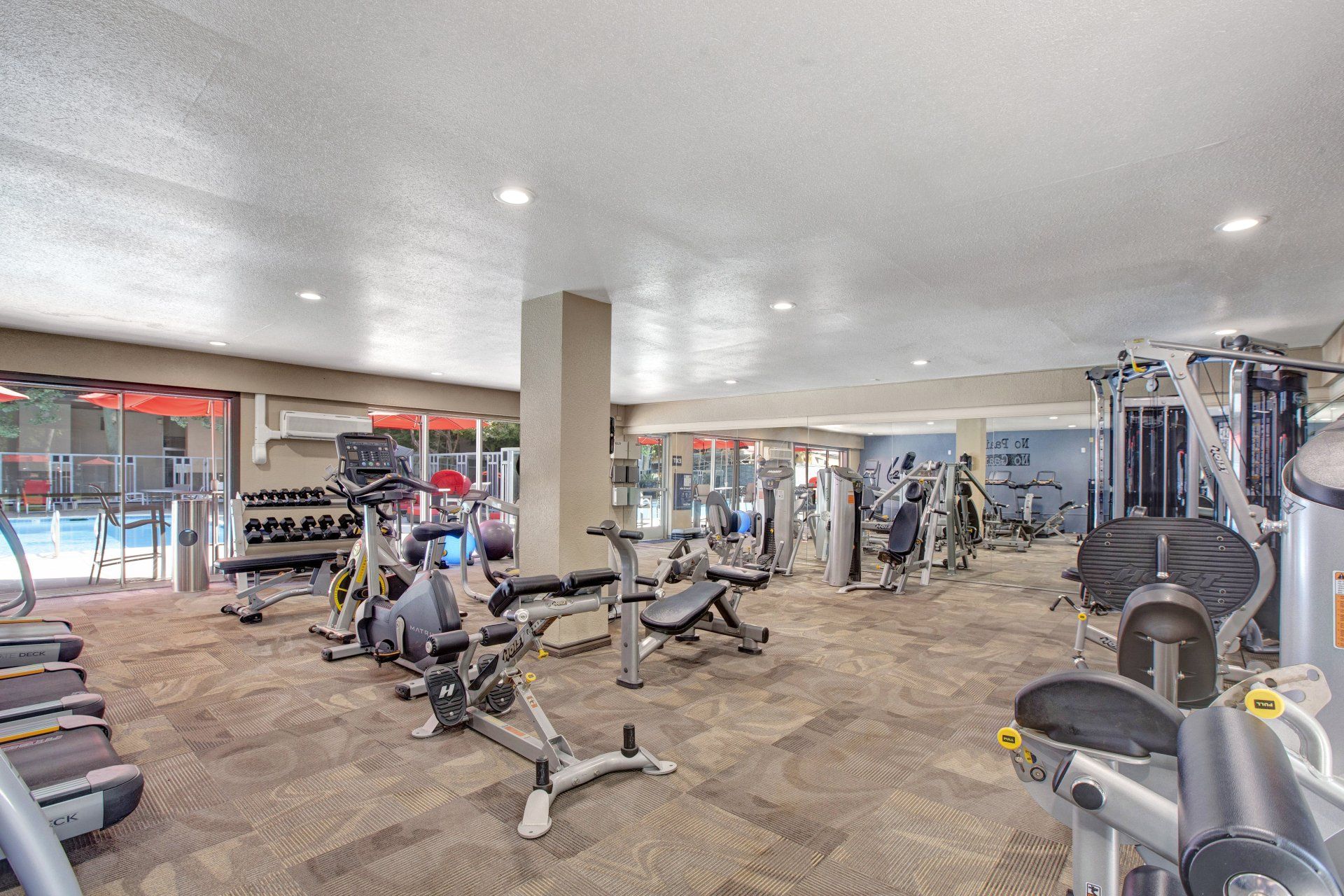 A large gym filled with lots of exercise equipment at Capitol Towers.