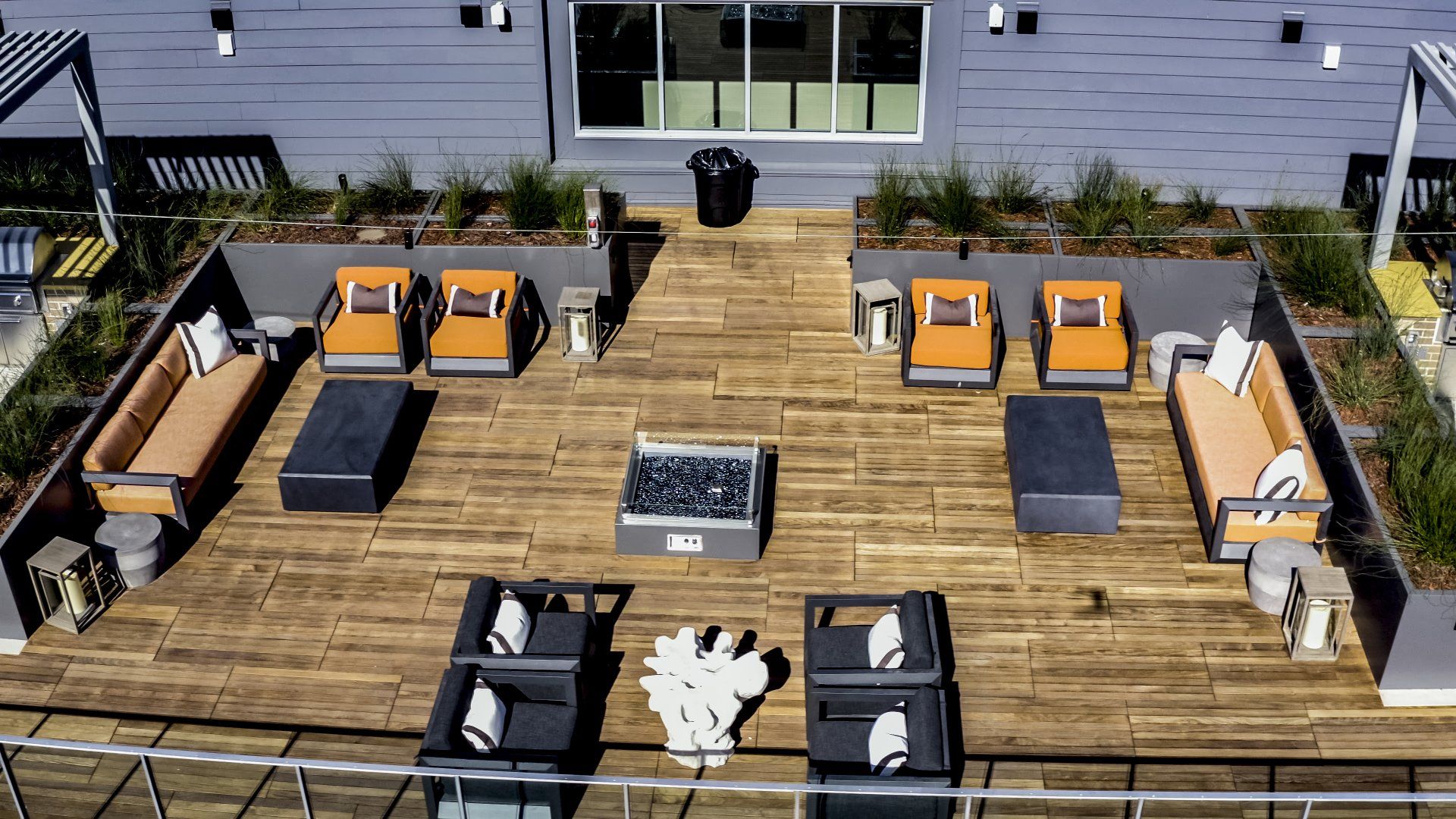 An aerial view of a rooftop deck with furniture and a fire pit at Capitol Towers.