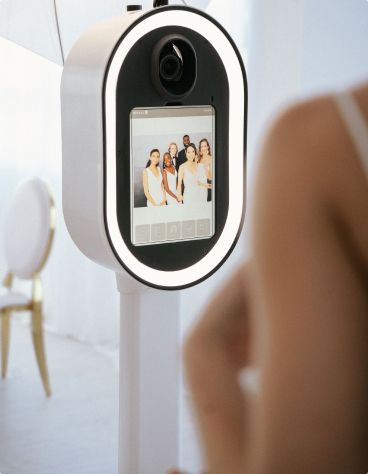 A woman is taking a picture of a group of people in a photo booth.