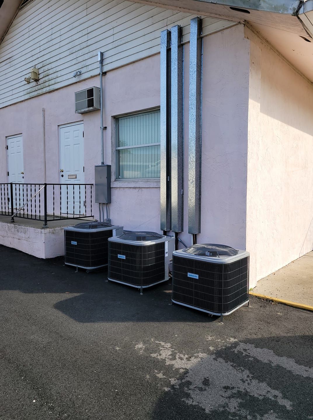 Shiny metallic HVAC ventilation ducts installed on a flat commercial building rooftop under a cloudy sky. Shiny metallic HVAC ventilation ducts installed on a flat commercial building rooftop under a cloudy sky.