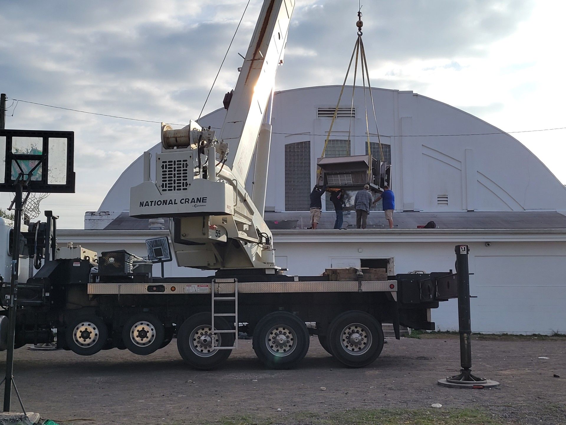 A technician in a blue shirt installing a white wall-mounted air conditioner in a bright room. A technician in a blue shirt installing a white wall-mounted air conditioner in a bright room.
