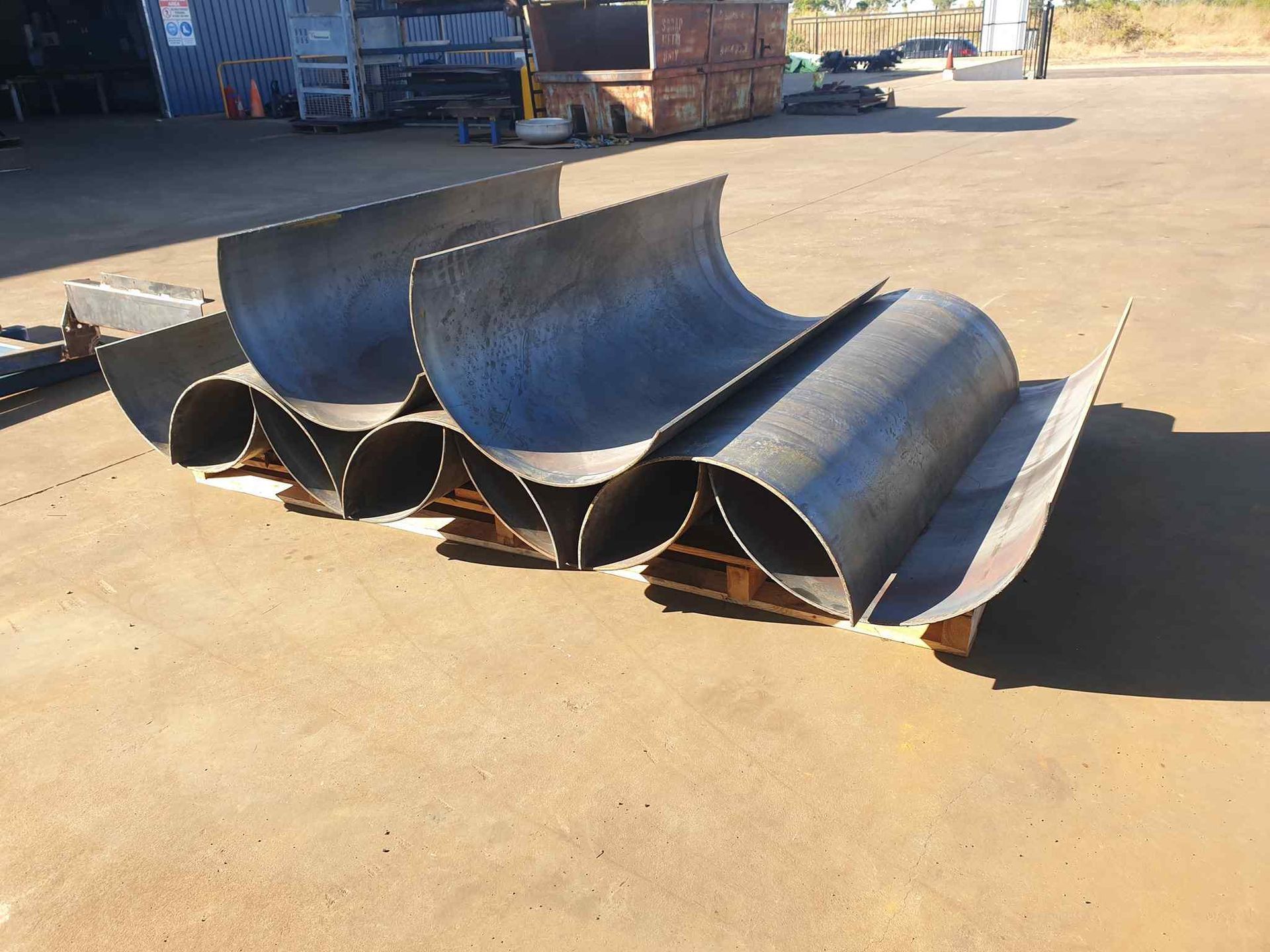 A Bunch of Metal Pipes Are Sitting on the Ground — Roll Press NT In Tivendale, NT