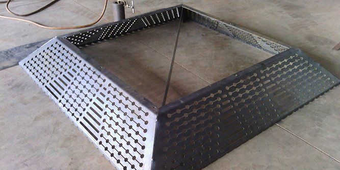 A Metal Object With Holes in It is Sitting on a Concrete Floor — Roll Press NT In Tivendale, NT