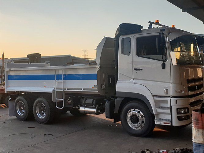 A White Dump Truck is Parked in a Parking Lot — Roll Press NT In Tivendale, NT