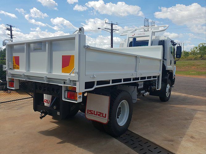 A White Dump Truck is Parked in a Parking Lot — Roll Press NT In Tivendale, NT