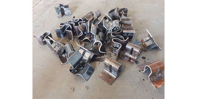 A Pile of Metal Clips Are Sitting on Top of a Wooden Table — Roll Press NT In Tivendale, NT