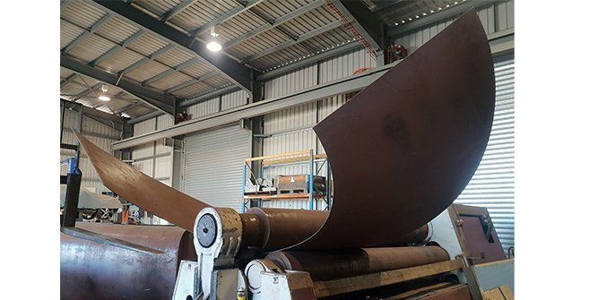A Large Piece of Metal is Sitting on Top of a Machine in a Warehouse — Roll Press NT In Tivendale, NT