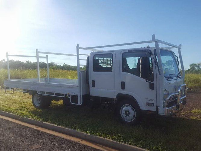 A White Truck With a Flat Bed is Parked on the Side of the Road — Roll Press NT In Tivendale, NT
