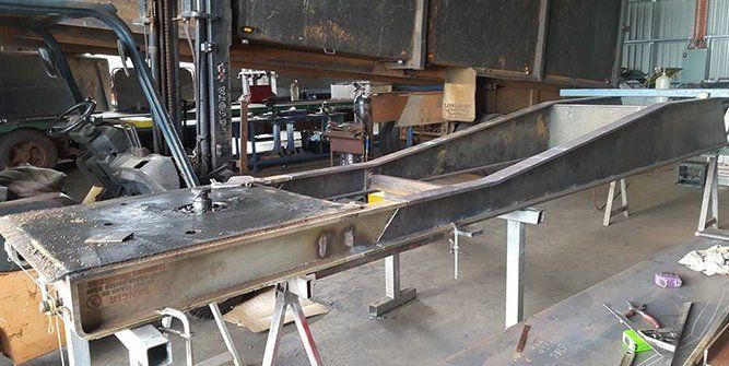 A Large Piece of Metal is Sitting on Top of a Table in a Garage — Roll Press NT In Tivendale, NT