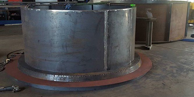 A Large Metal Pipe is Sitting on Top of a Wooden Table in a Factory — Roll Press NT In Tivendale, NT