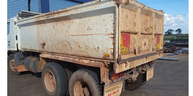 A White Dump Truck is Parked in a Parking Lot — Roll Press NT In Tivendale, NT
