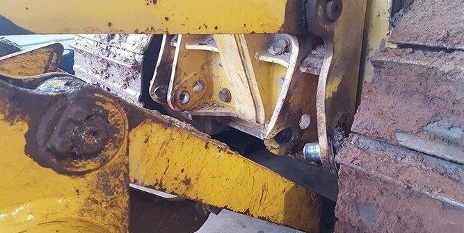 A Close Up of a Yellow Machine Sitting Next to a Brick Wall — Roll Press NT In Tivendale, NT