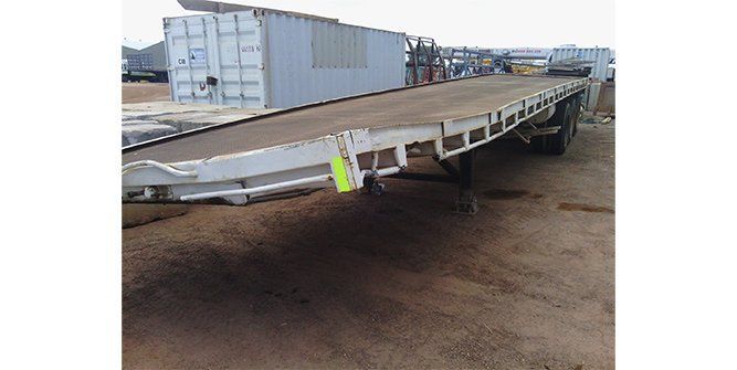 A Flatbed Trailer is Sitting on Top of a Dirt Field — Roll Press NT In Tivendale, NT
