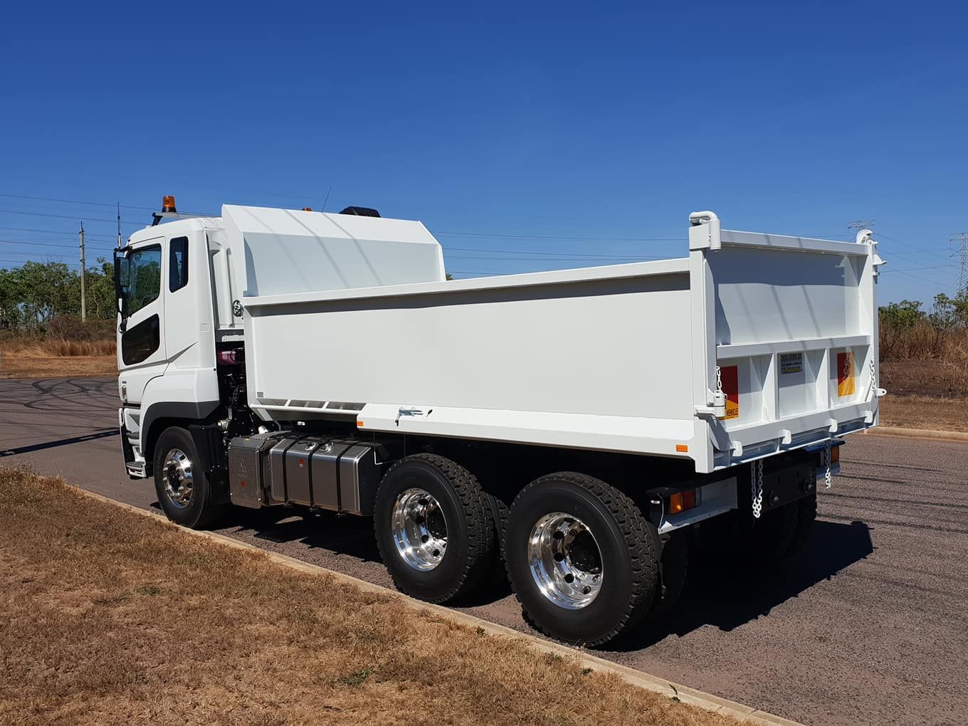 A White Dump Truck is Parked on the Side of the Road — Roll Press NT In Palmerston, NT